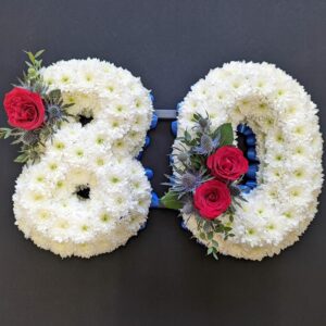 80 number funeral tribute in white chrysanthemums with red roses and blue thistles