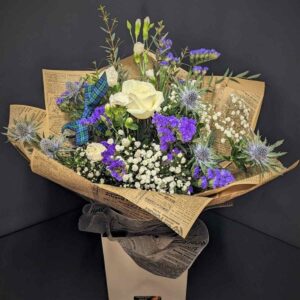 Scottish Thistle & Rose Bouquet with white roses, thistles, purple flowers and Gypsophila wrapped in vintage newspaper paper with tartan ribbon – Anastasia Florists Aberdeen