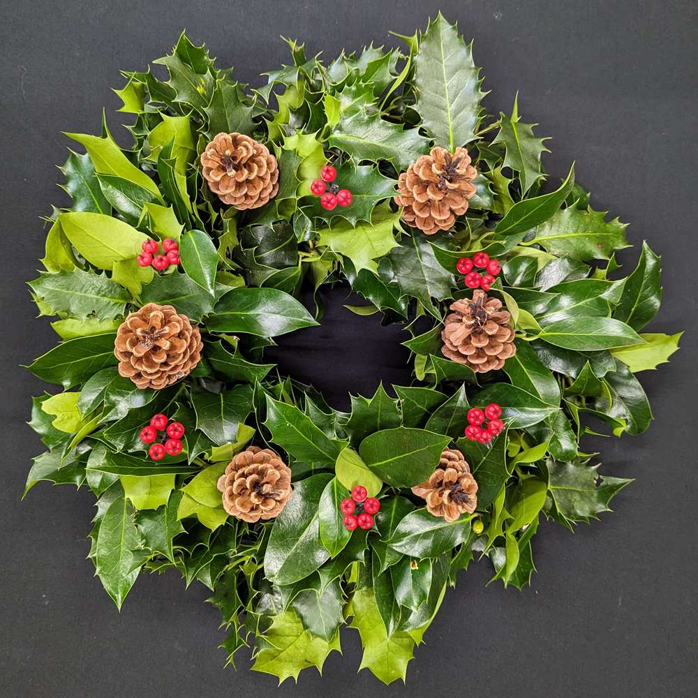 Holly graveside Christmas wreath with pinecones and red berry accents