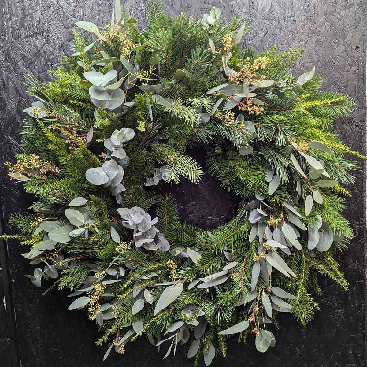 Natural pine and eucalyptus Christmas door wreath with mixed seasonal greenery