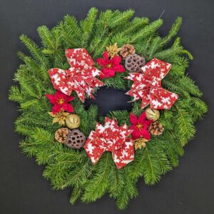 Pine Christmas door wreath with red-and-white poinsettia bows, red poinsettia accents, gold baubles and pinecones