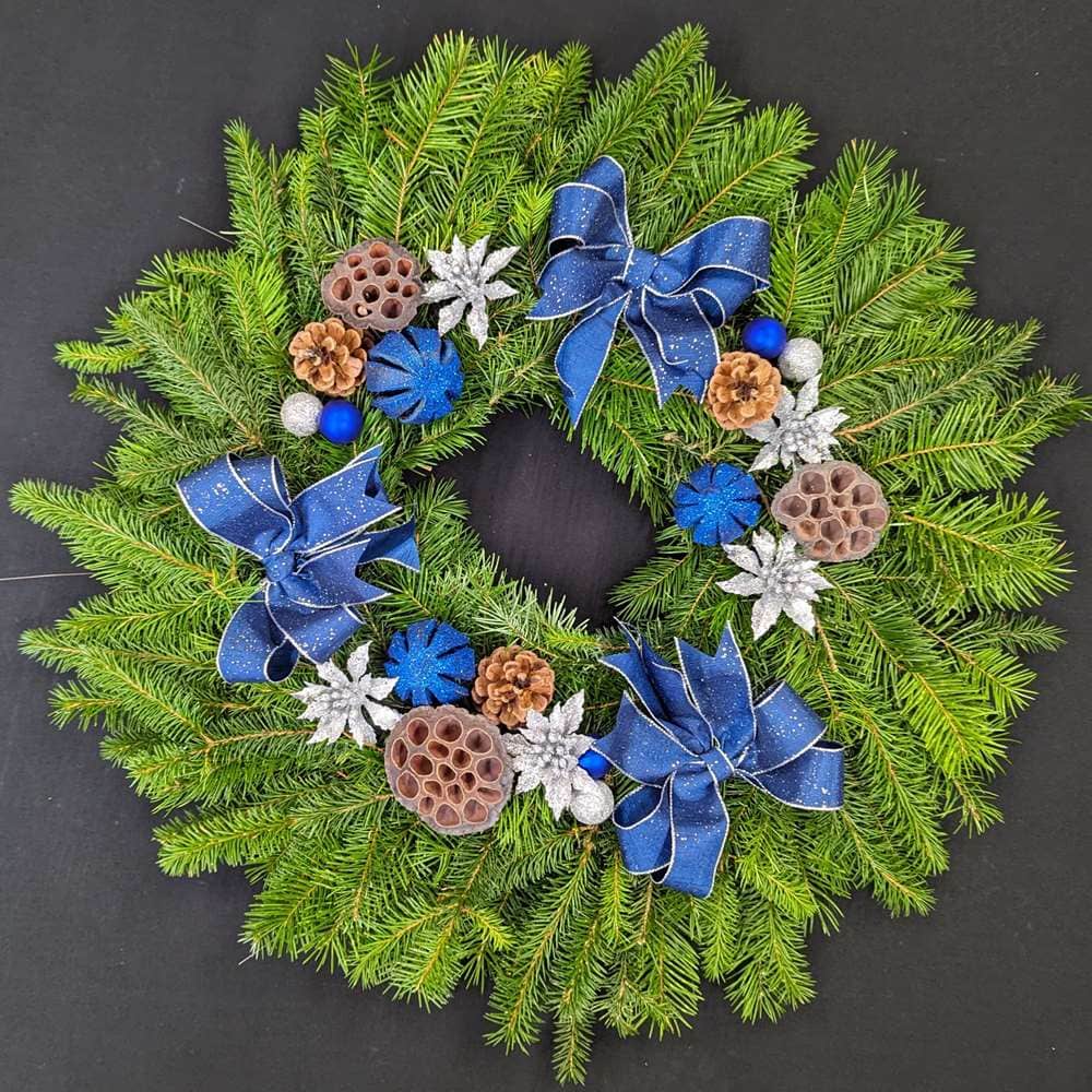 Blue and silver pine Christmas door wreath with bows, pinecones and lotus pods