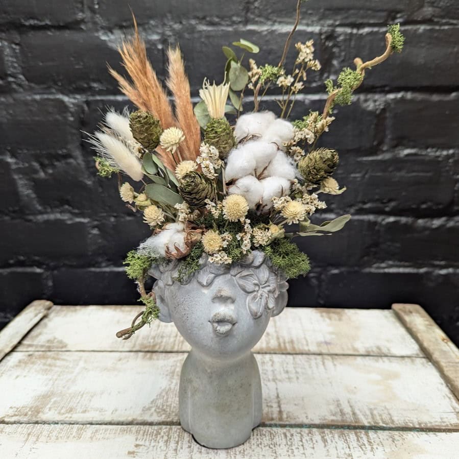 Dried flower face vase arrangement with cotton, cones, grasses and preserved foliage in a stone-style head vase – Anastasia Florists Aberdeen - Angle view