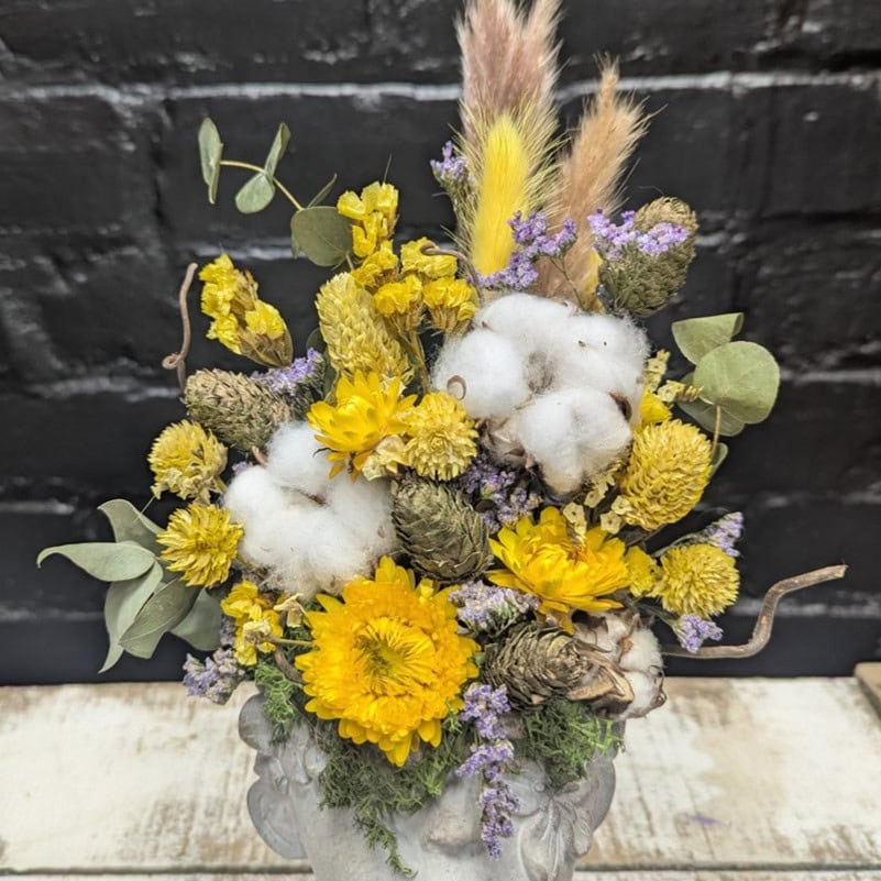 Bright dried flower face vase arrangement with yellow blooms, cotton, grasses and preserved foliage in a stone-style head vase – Anastasia Florists Aberdeen - Close Up