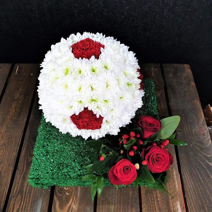 Floral football tribute with white roses and greenery – side view