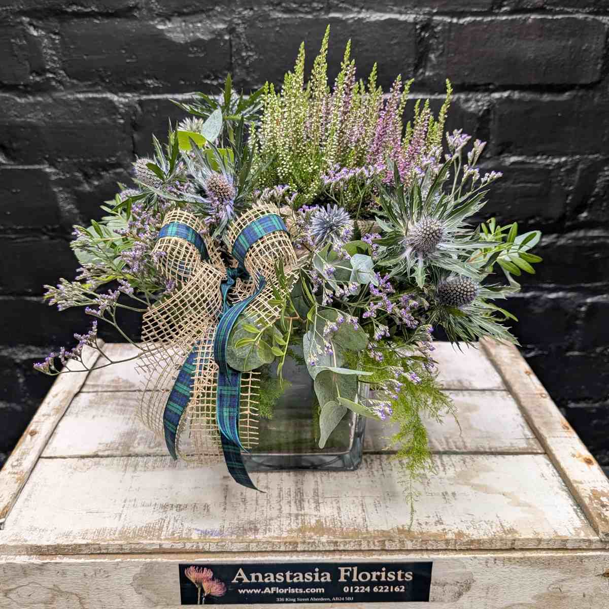 Scottish thistle and heather flower arrangement with lilac blooms, foliage and tartan ribbon in a glass cube vase – Anastasia Florists Aberdeen - Side view