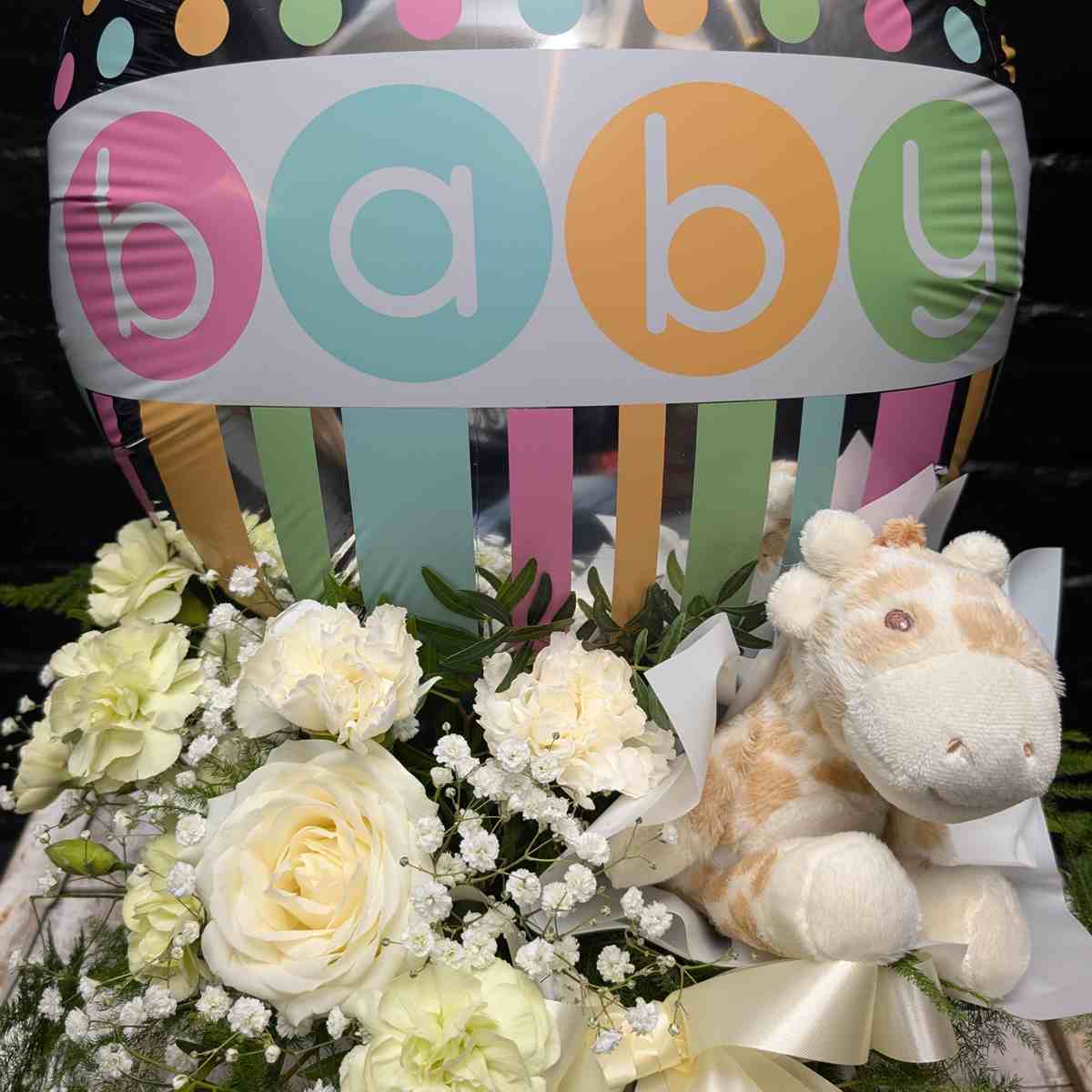 New baby gift with colourful “Baby” balloon, soft toy and cream and white flower arrangement in a white hat box on a wooden crate – Anastasia Florists Aberdeen - Close Up