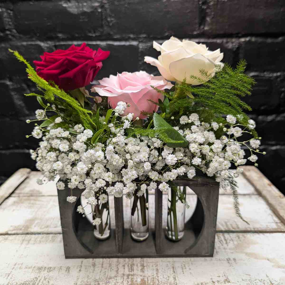 Trio of red, pink, and white roses in a simple arrangement – side view