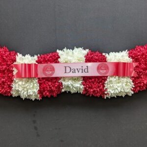 Red and white funeral tribute in the shape of a football scarf