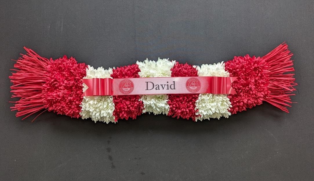 Red and white funeral tribute in the shape of a football scarf
