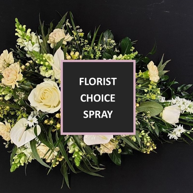 Florist choice single ended funeral spray in white and cream flowers with green foliage and a central box reading “Florist Choice Spray”.