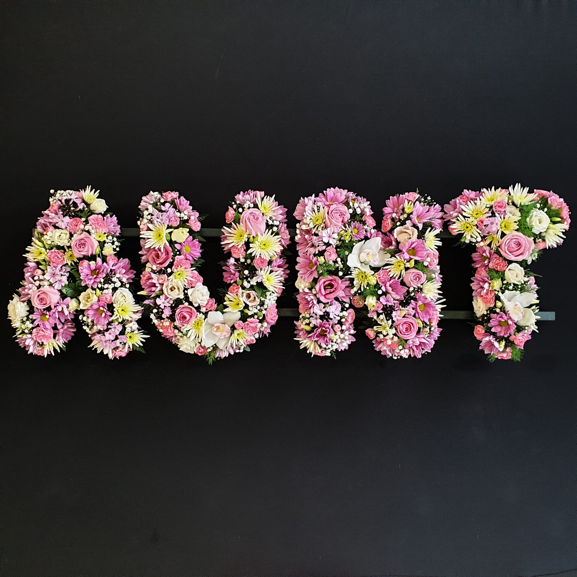 Funeral tribute flowers spelling 'Aunt'