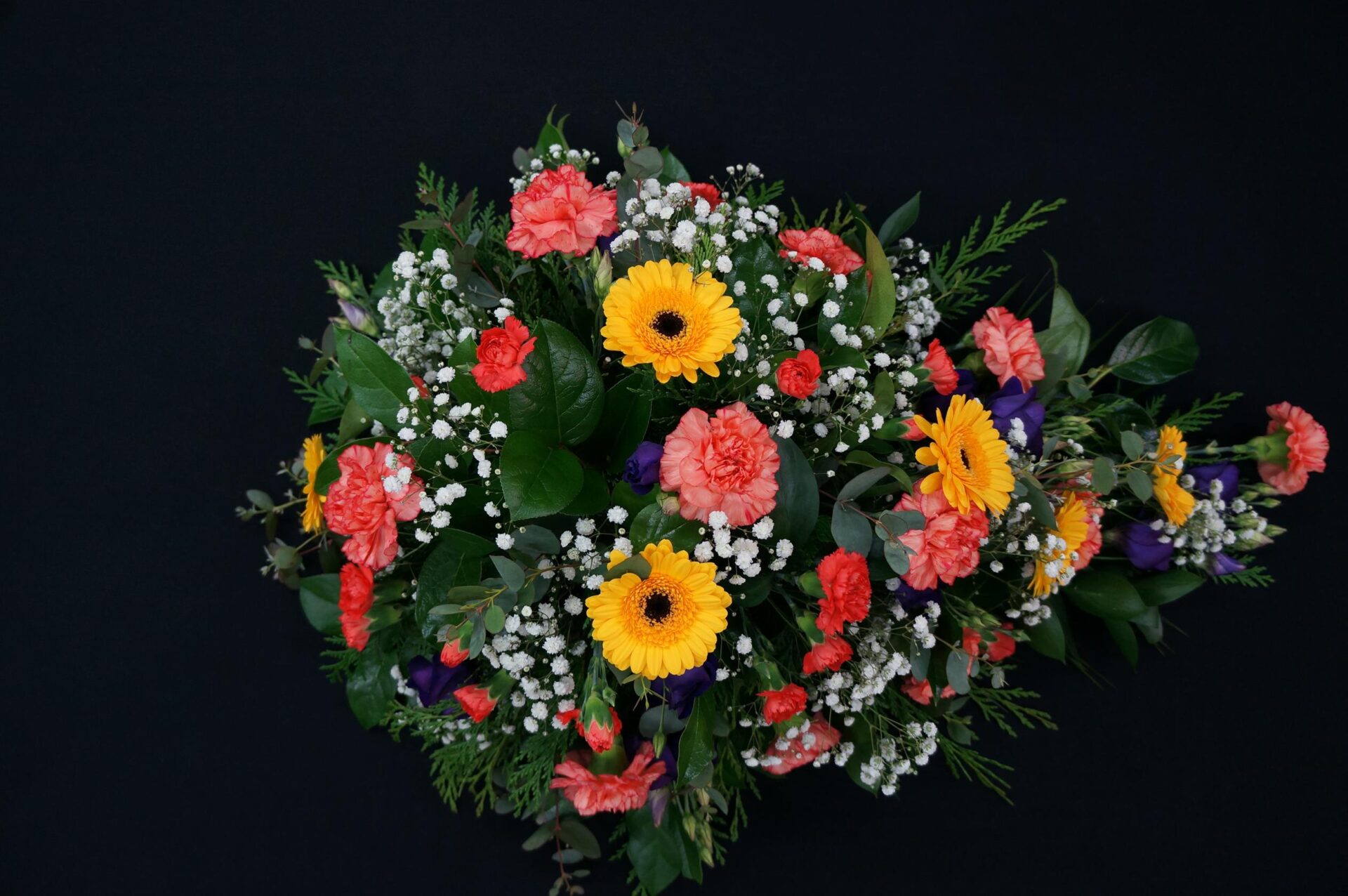Funeral spray with vibrant flowers and greenery