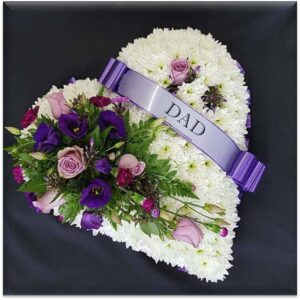 White chrysanthemum heart funeral tribute with lilac and purple flowers and Dad ribbon on a black background