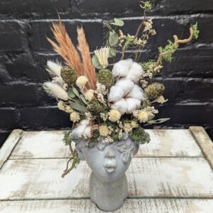Dried flower face vase arrangement with cotton, cones, grasses and preserved foliage in a stone-style head vase – Anastasia Florists Aberdeen