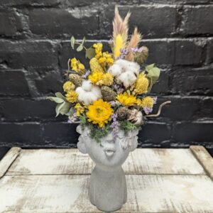 Bright dried flower face vase arrangement with yellow blooms, cotton, grasses and preserved foliage in a stone-style head vase – Anastasia Florists Aberdeen