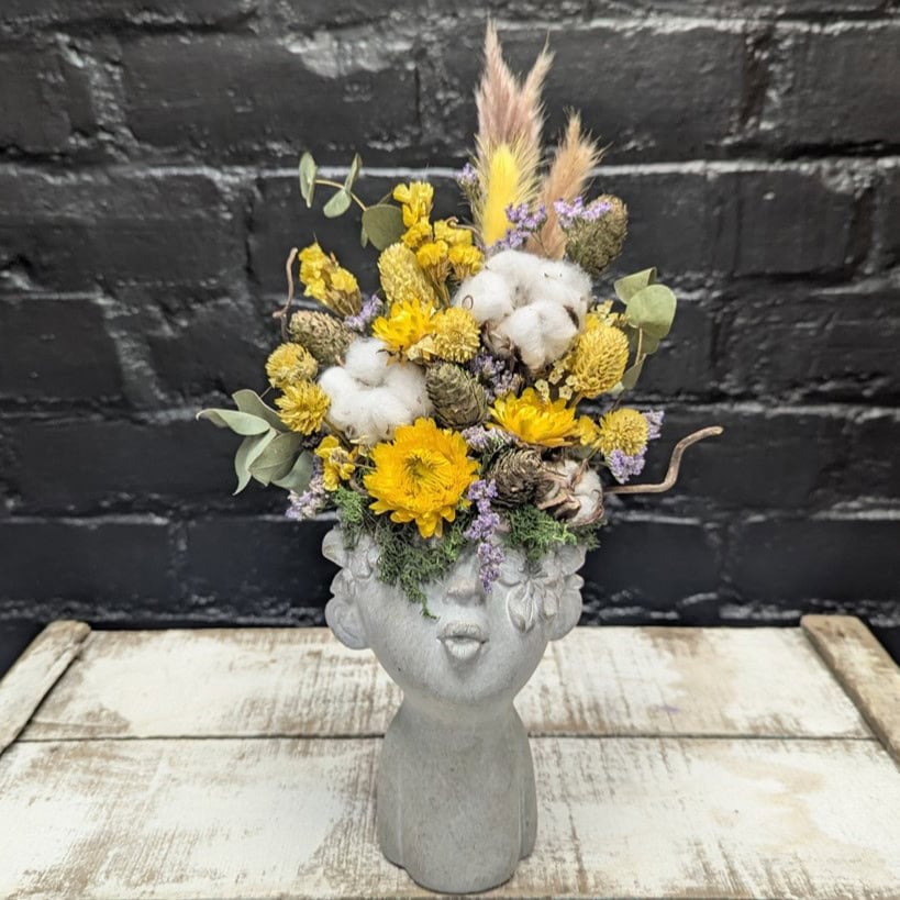 Bright dried flower face vase arrangement with yellow blooms, cotton, grasses and preserved foliage in a stone-style head vase – Anastasia Florists Aberdeen