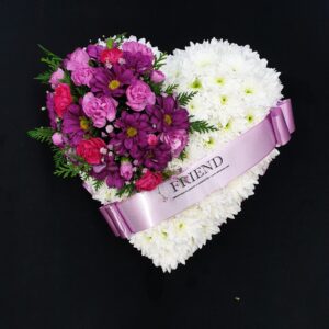 White chrysanthemum heart funeral tribute with purple and pink flowers and Friend ribbon on a black background