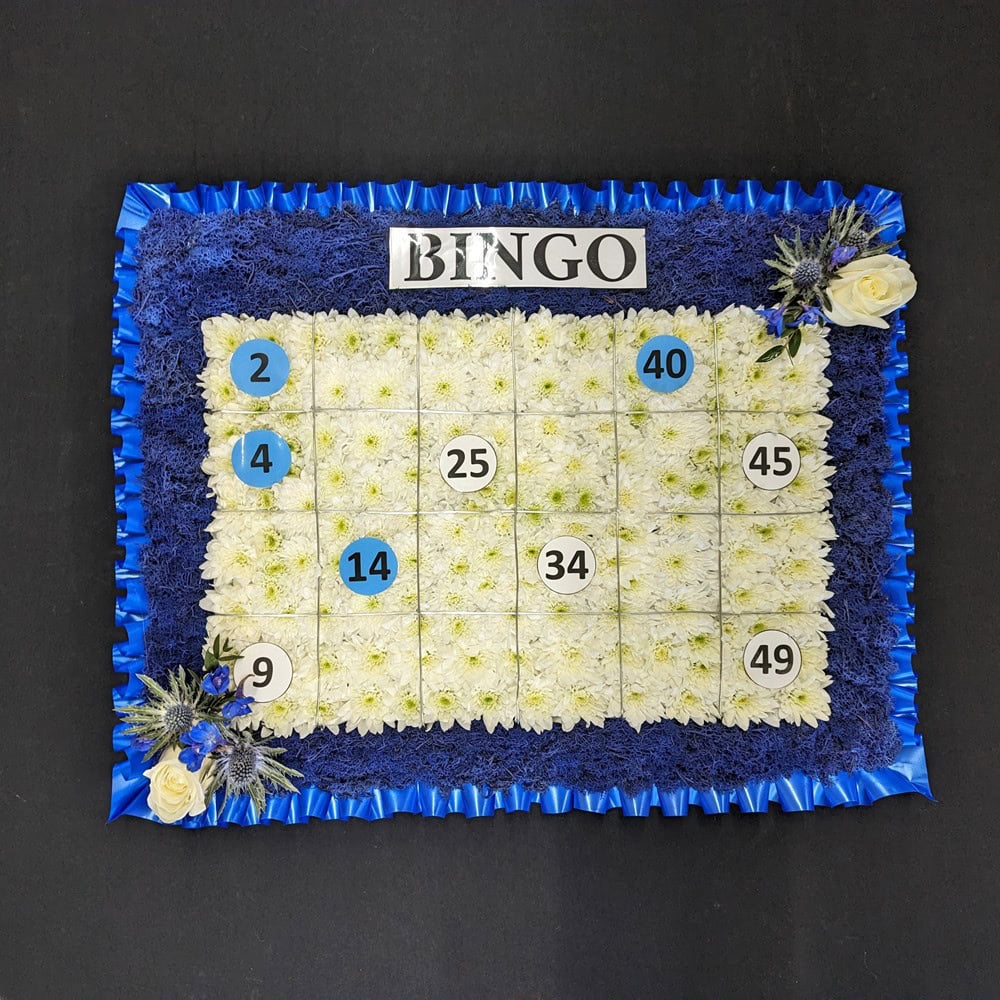 Floral funeral bingo board tribute with white and blue flowers
