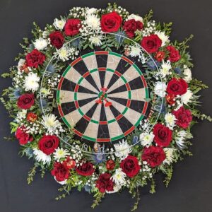 Funeral flower tribute with dartboard and red roses
