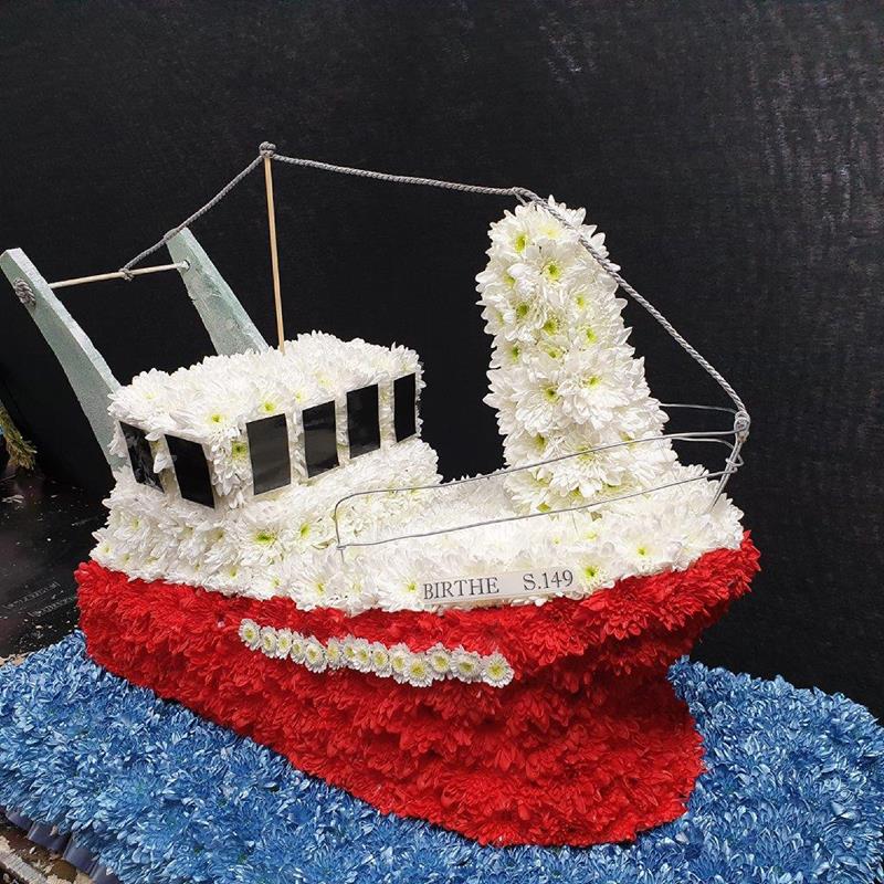 Floral funeral tribute shaped like a fishing boat