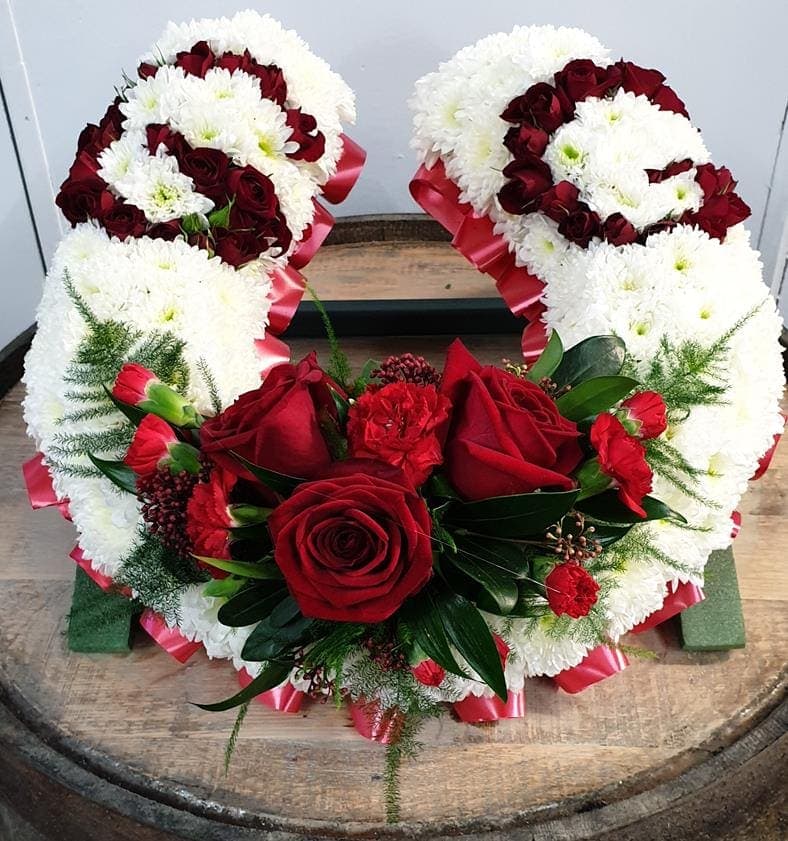 Funeral horse shoe with red roses and white chrysanthemums