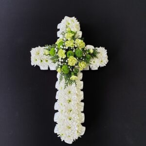 Green and white funeral cross with chrysanthemum base, lime carnations and green button chrysanthemums