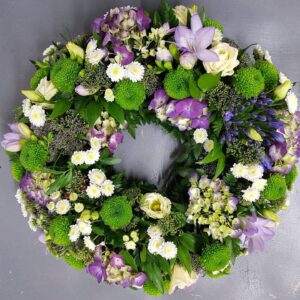 Lilac and lime garden-style funeral wreath with hydrangea, lisianthus and green button chrysanthemums