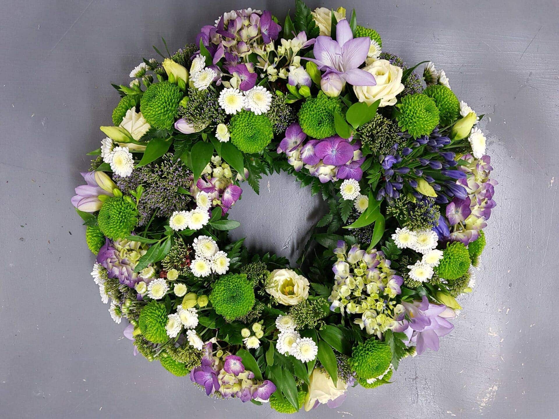 Lilac and lime garden-style funeral wreath with hydrangea, lisianthus and green button chrysanthemums