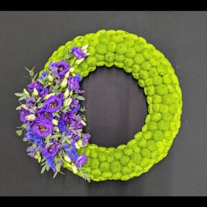 Lime green chrysanthemum funeral wreath with purple lisianthus side spray