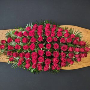 All red rose coffin spray on wooden coffin