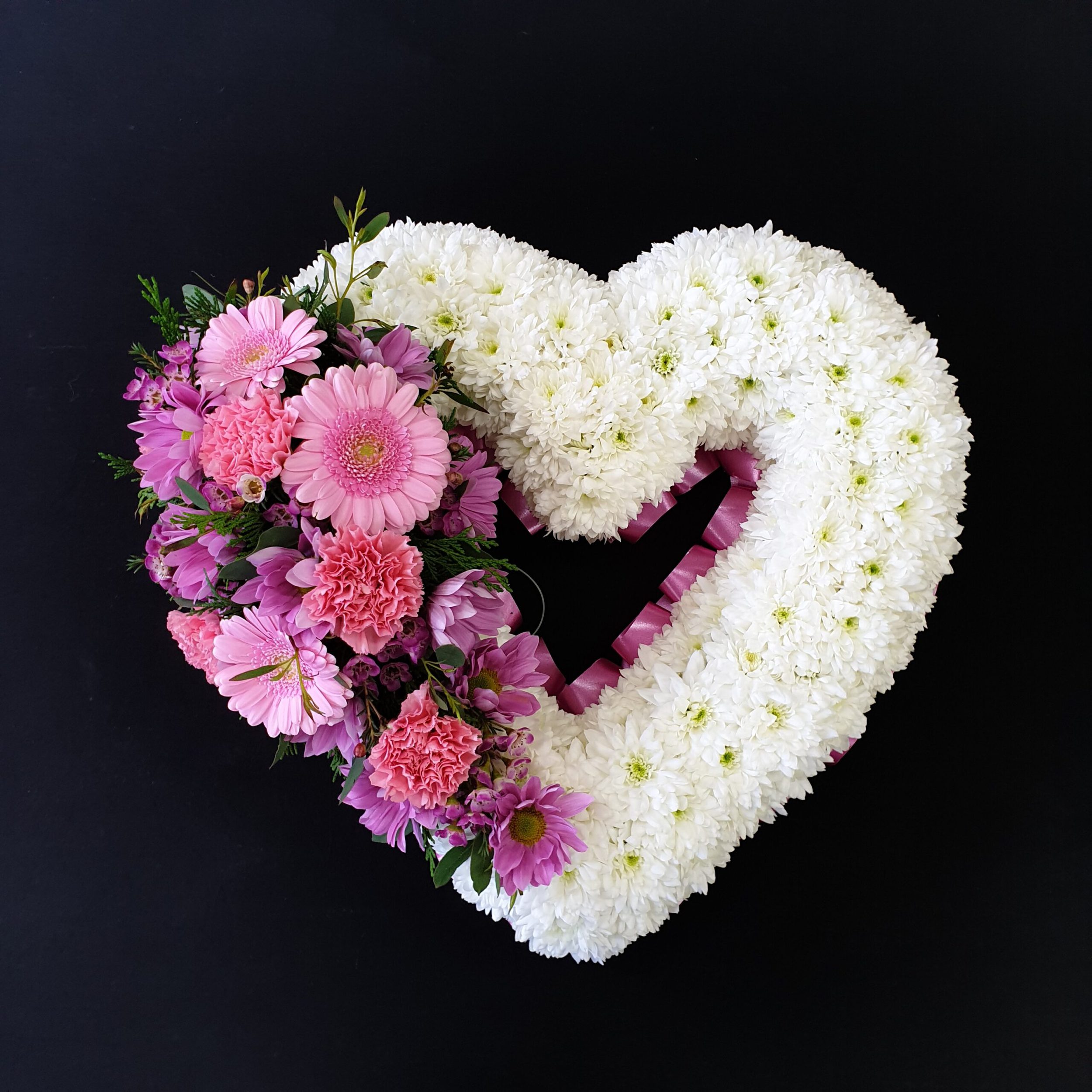 Heart-shaped white and pink floral tribute