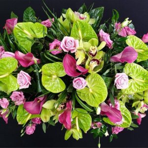 Modern pink and lime green coffin spray with anthuriums, calla lilies, orchids and roses