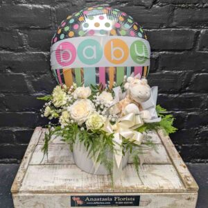 New baby gift with colourful “Baby” balloon, soft toy and cream and white flower arrangement in a white hat box on a wooden crate – Anastasia Florists Aberdeen