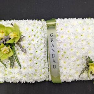 Open book funeral flower tribute with white chrysanthemums and green orchids