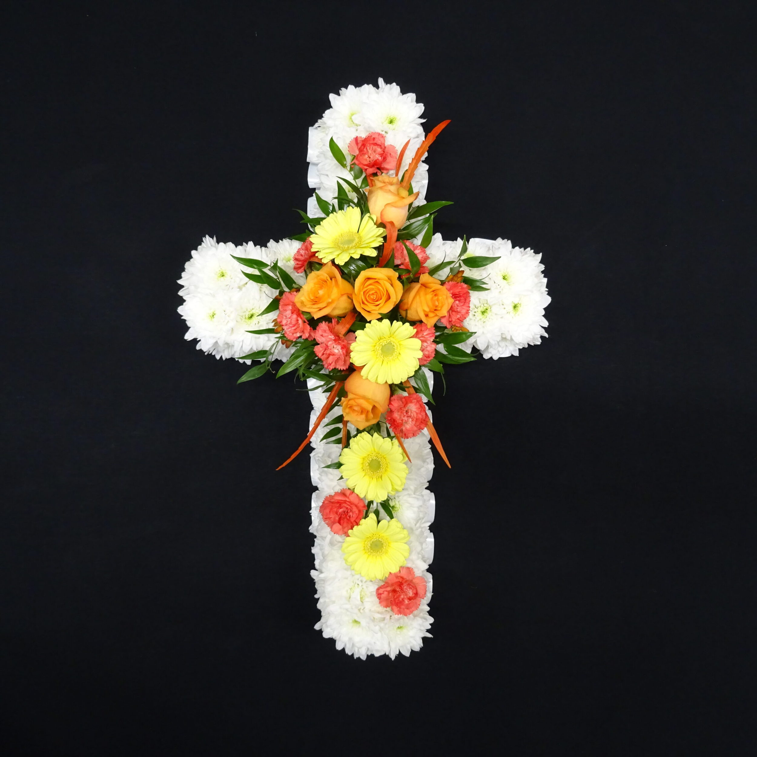 Orange and yellow funeral cross with white chrysanthemum base, roses, gerberas and carnations