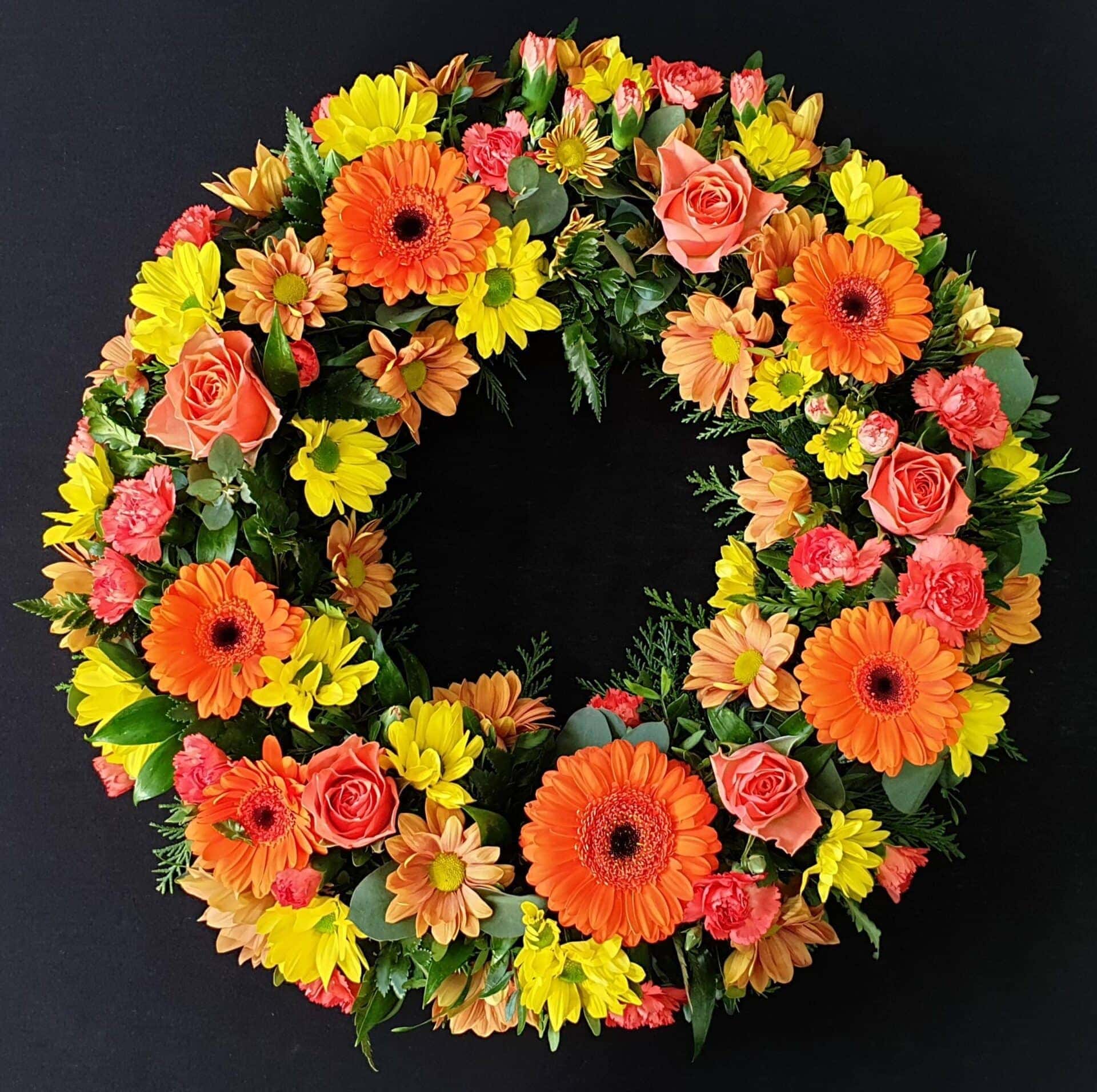 Bright funeral wreath with mixed flowers
