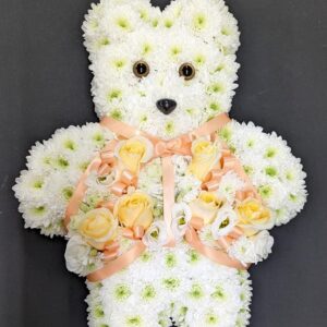 Floral teddy bear funeral tribute with white and yellow flowers