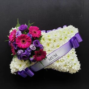 Mum pink and purple funeral pillow tribute with white chrysanthemum base and purple ribbon