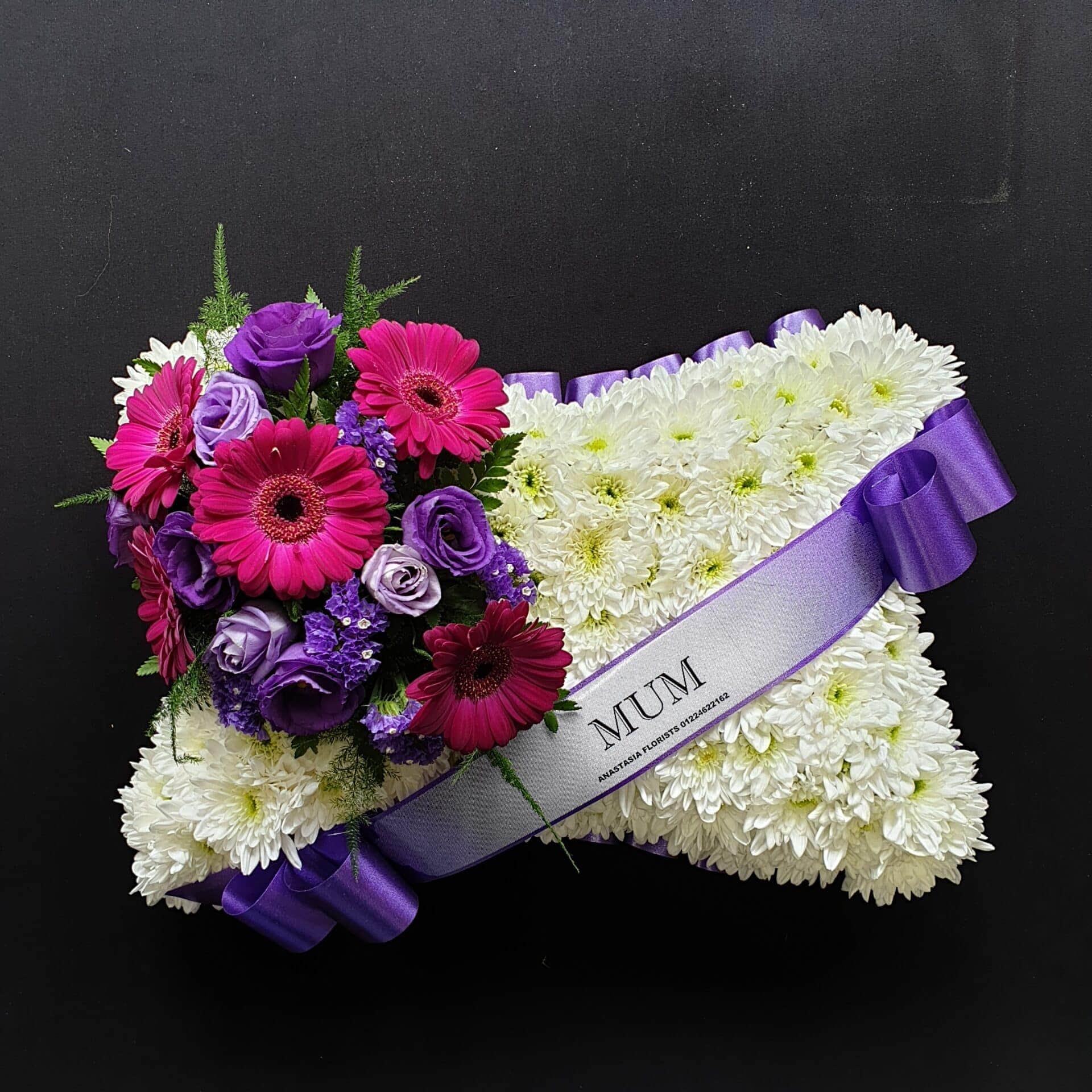 Mum pink and purple funeral pillow tribute with white chrysanthemum base and purple ribbon