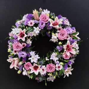 Pink and purple funeral wreath with lilies and roses