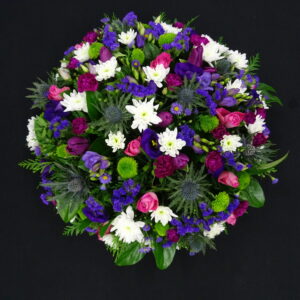 Purple and pink funeral posy with thistles, roses, lisianthus and white chrysanthemums