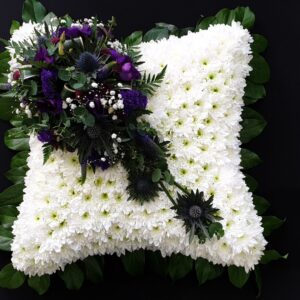 White flower funeral cushion with calm greenery
