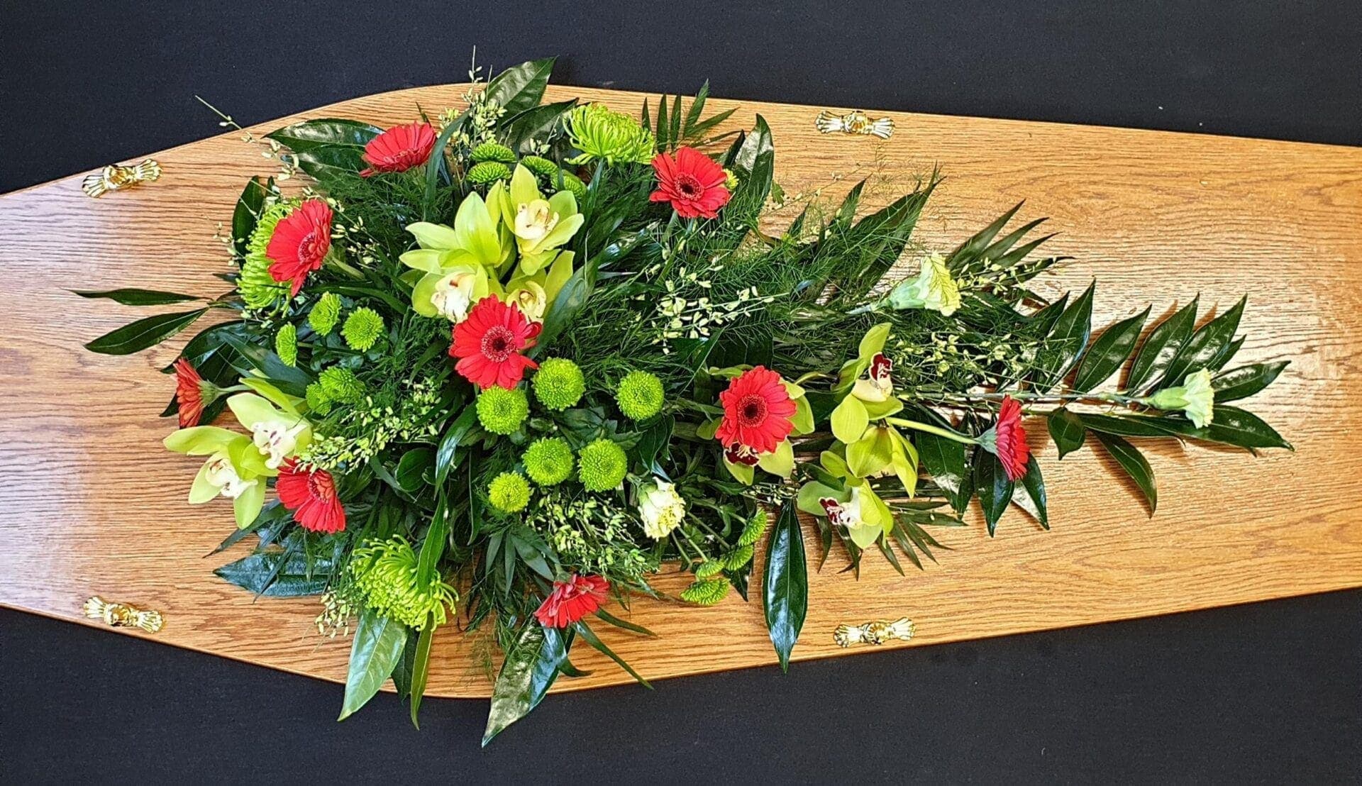 Funeral single ended spray with red gerberas and orchids.
