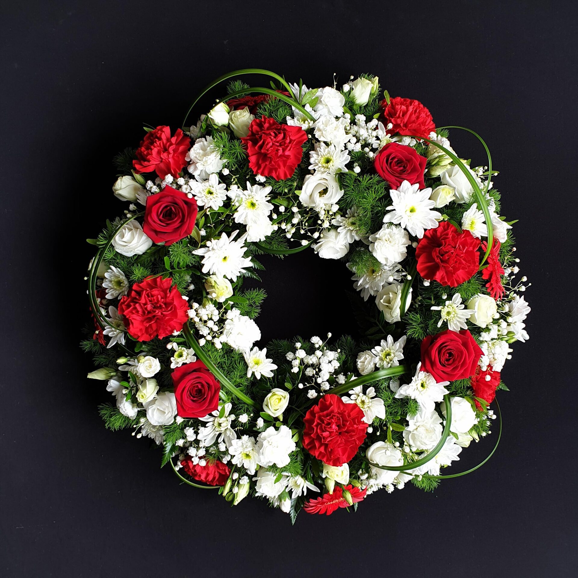 Red rose and white flower funeral wreath tribute.