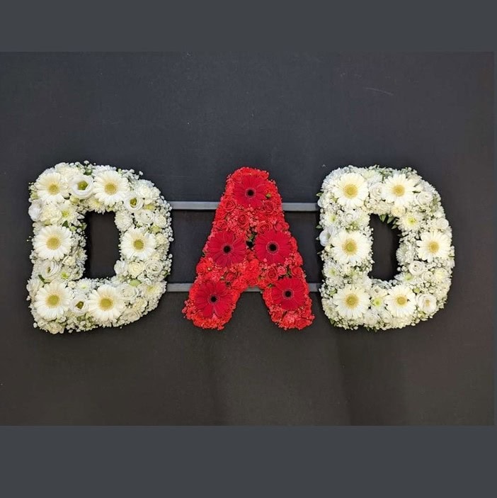 Red and white DAD funeral letter tribute with white floral Ds and a red floral A