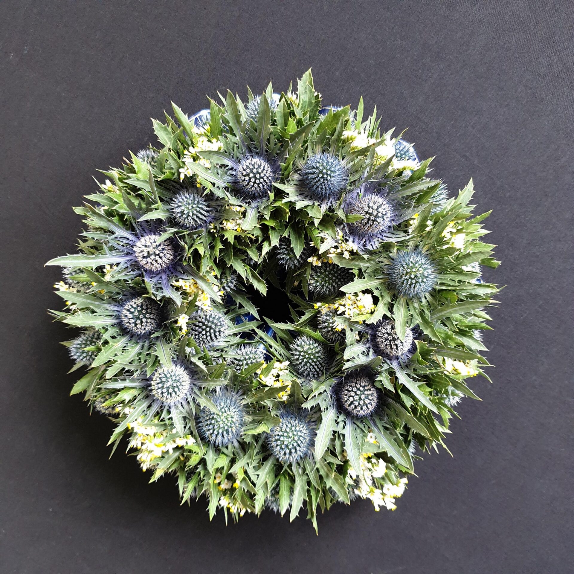 Scottish thistle funeral wreath with blue thistles and green foliage