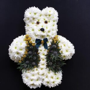 Scottish teddy bear funeral tribute made from white chrysanthemums with yellow billy balls, thistles and tartan bow tie from Anastasia Florists Aberdeen.
