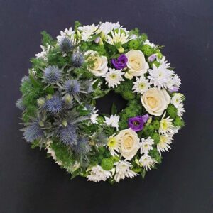 Scottish thistle and white rose funeral wreath with green button blooms and purple lisianthus