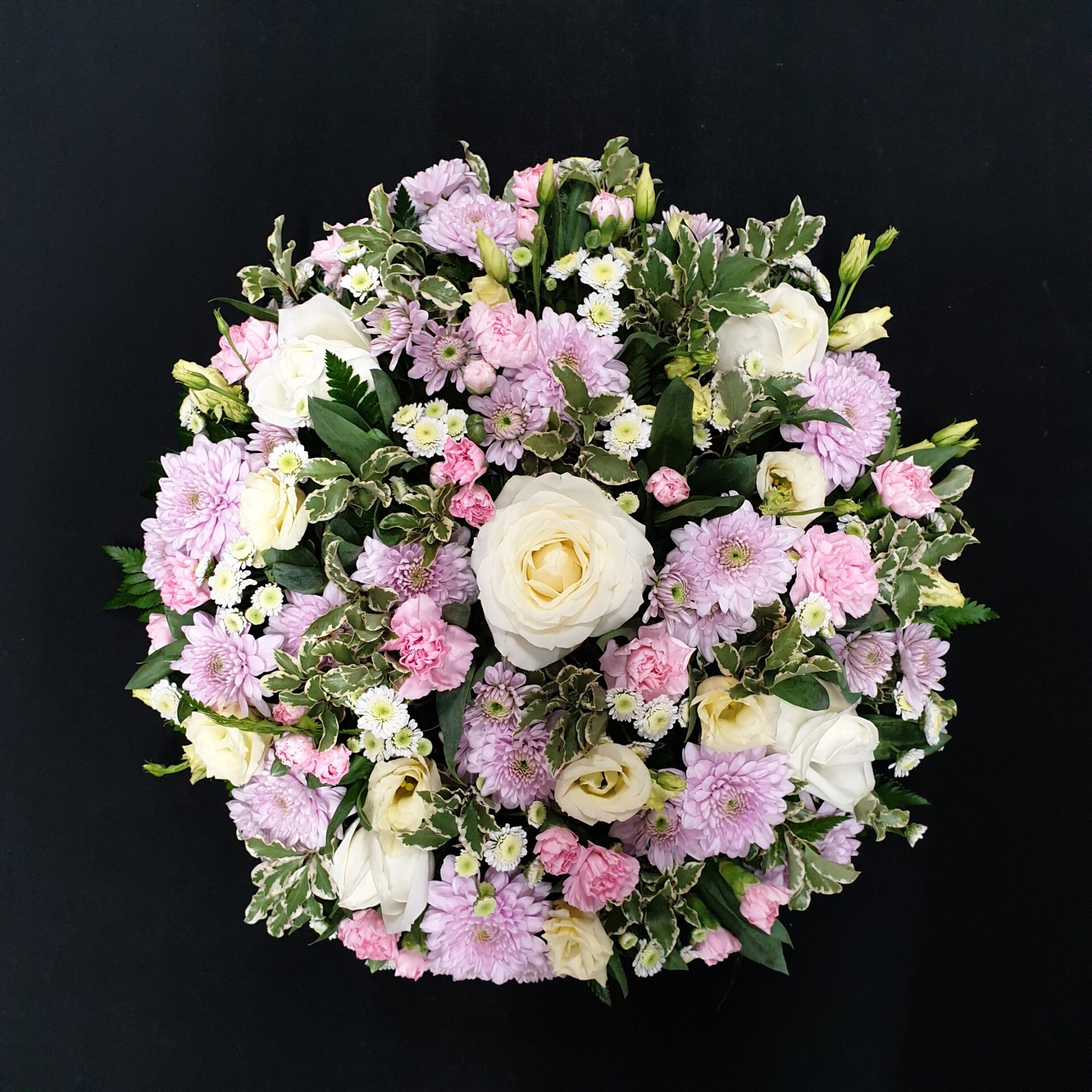 Pink and white funeral posy with roses and carnations